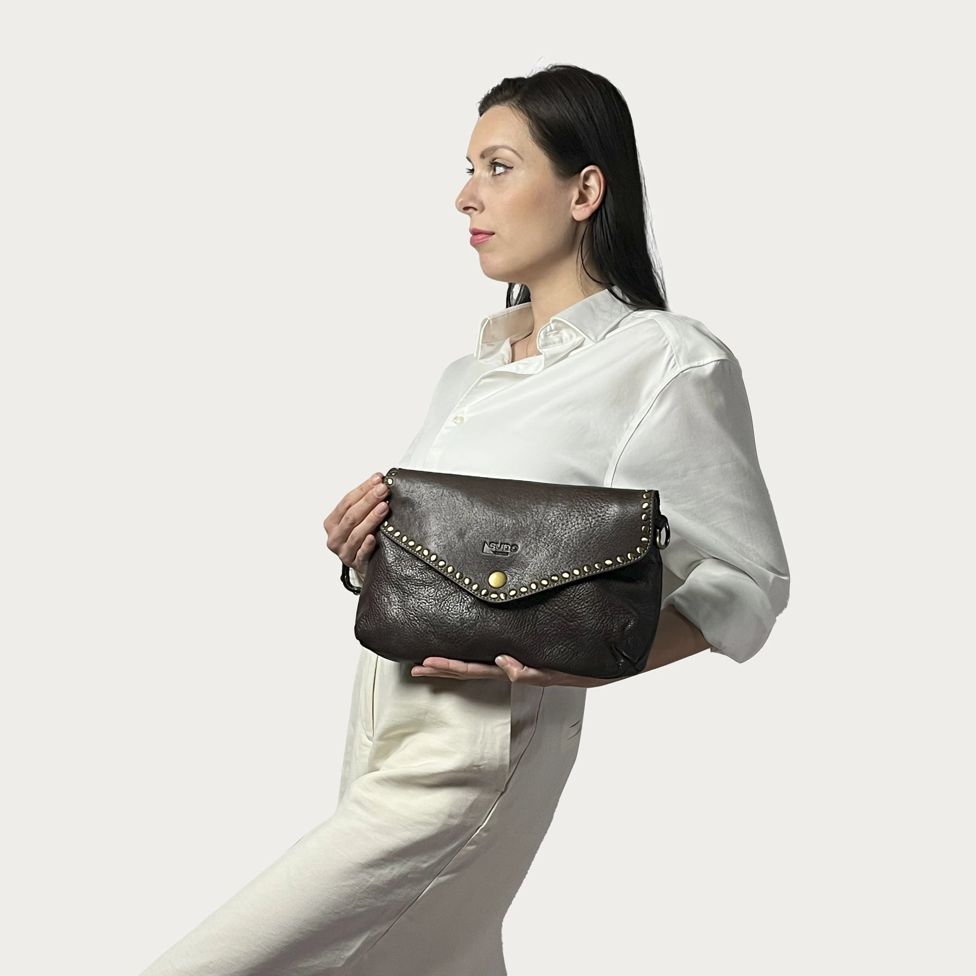 Brown Italian leather pochette — Solstice style — carried by model — Made in Tuscany