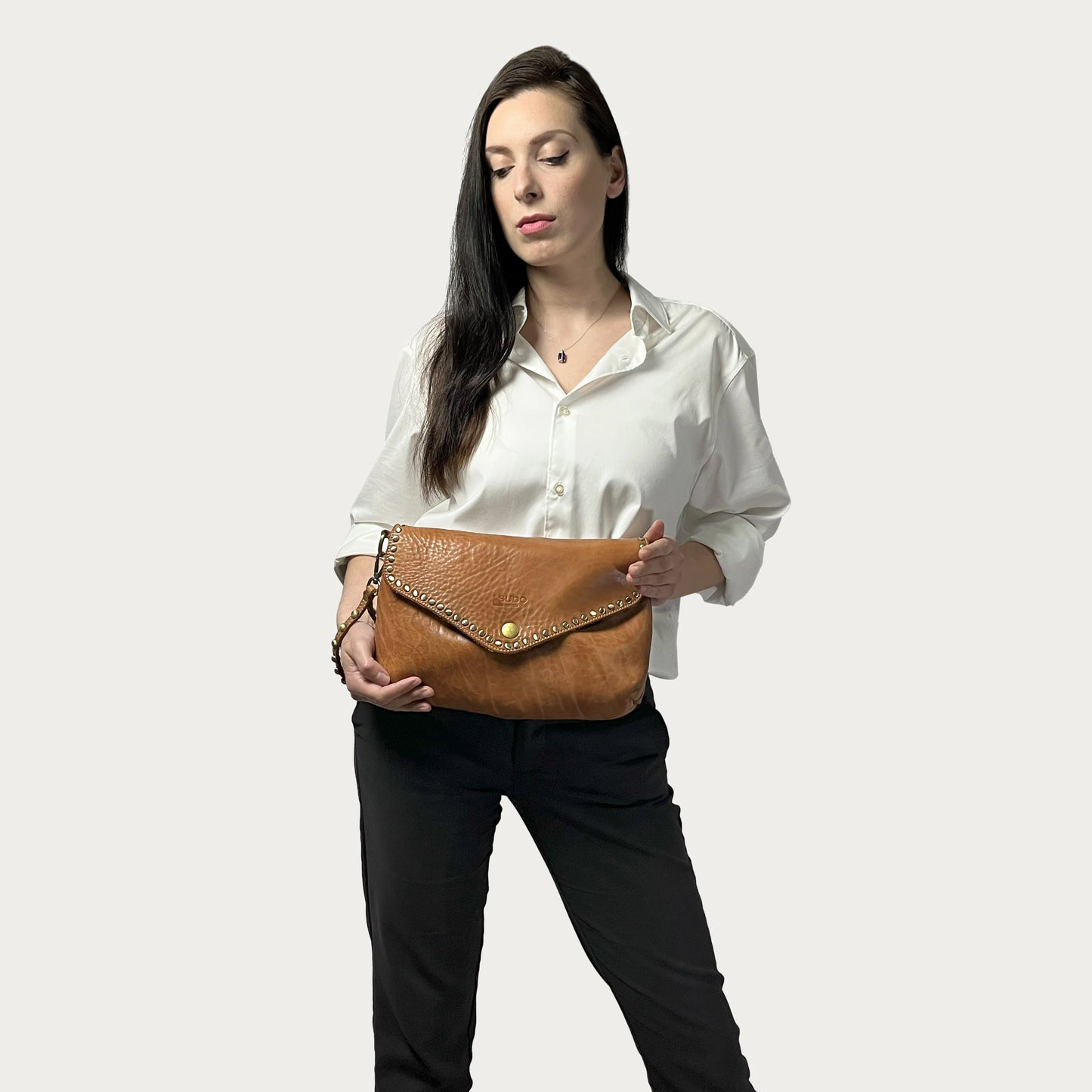 Cognac Italian leather pochette — Solstice style — carried by model — Made in Tuscany