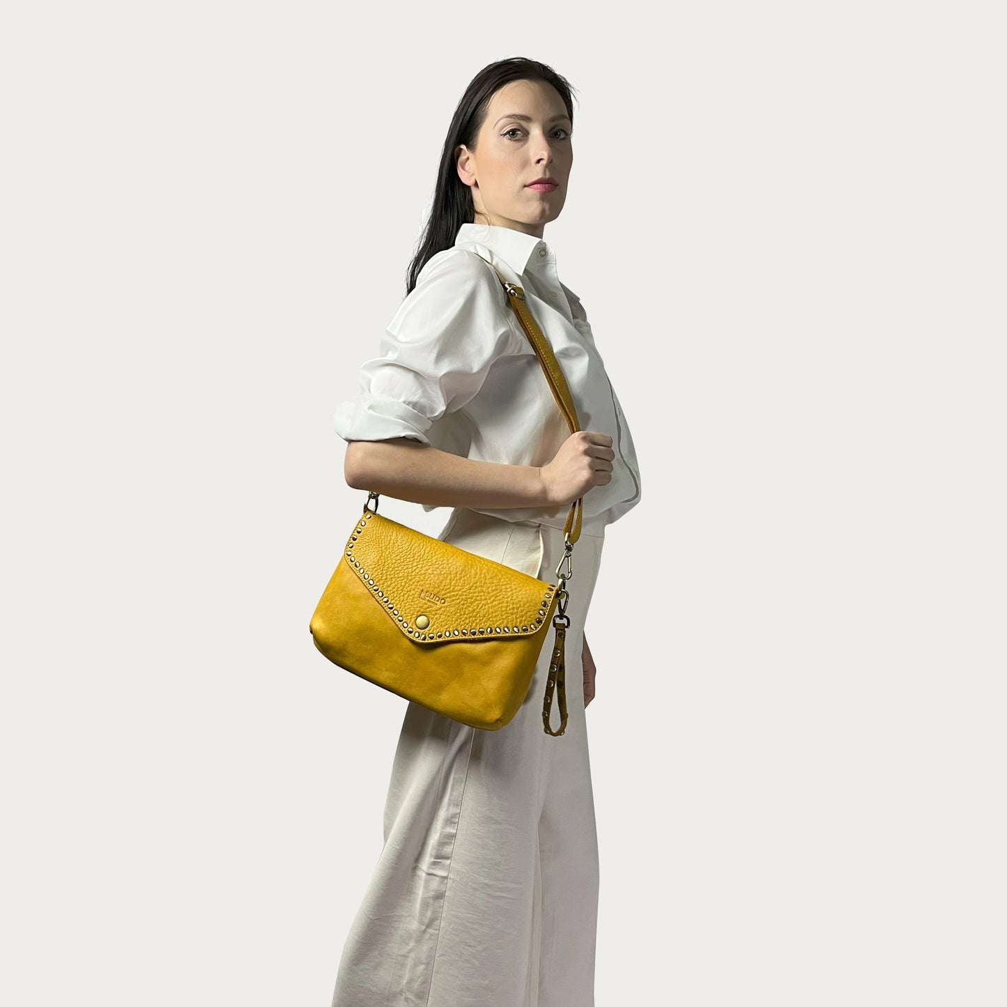 Mustard Italian leather pochette — Solstice style — carried by model — Made in Tuscany
